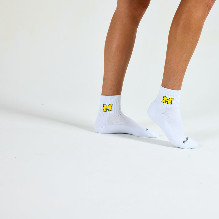 Woman wearing Del Campo Michigan Maize golf socks, studio shot, no shoes