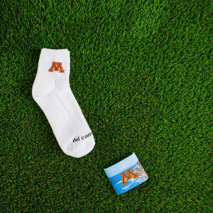 Flat lay of Del Campo Minnesota Golden Gophers golf socks with game-day props