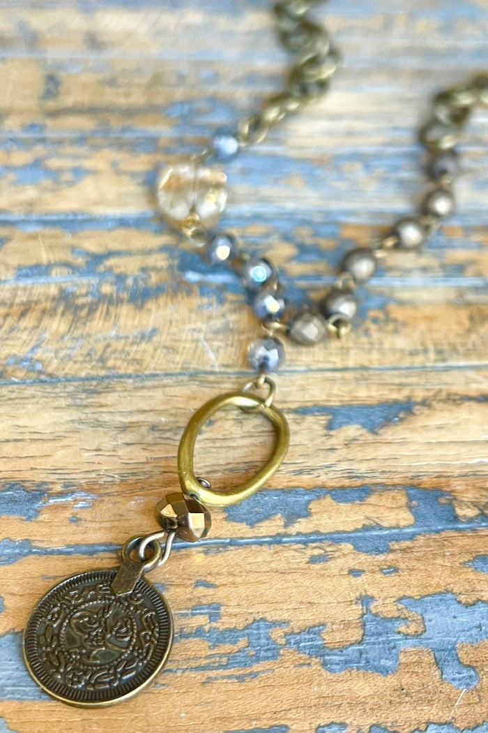 Short, lariat style necklace with intricate coin pendant. The strand is a chain link with gorgeous beading throughout. 11" long, 1" coin pendant