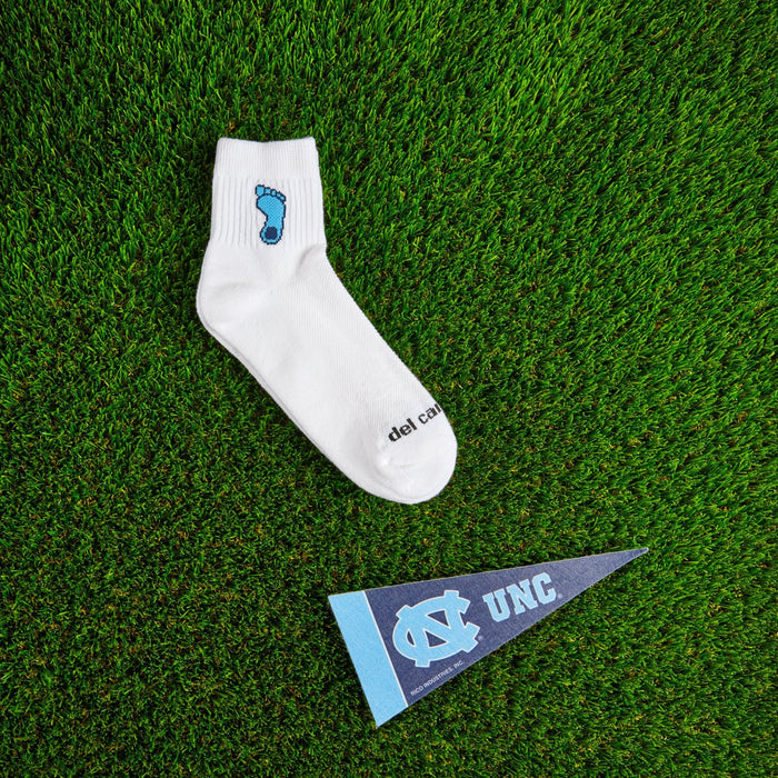Flat lay of Del Campo North Carolina Tar Heel golf socks with game-day props