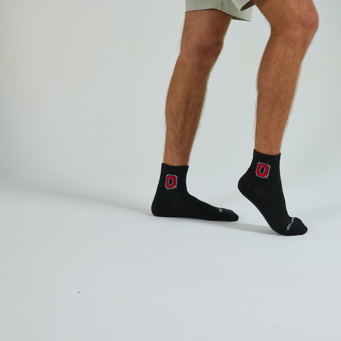 Man wearing Del Campo Ohio State Night Mode golf socks, studio shot, no shoes