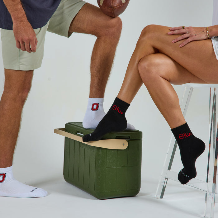 Two models wearing Del Campo Ohio State Pack golf socks in studio