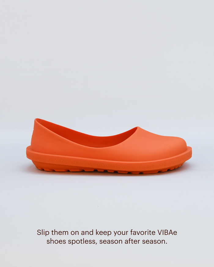 Orange rubber slip-on clog with textured sole and curved upper, shown in profile view.