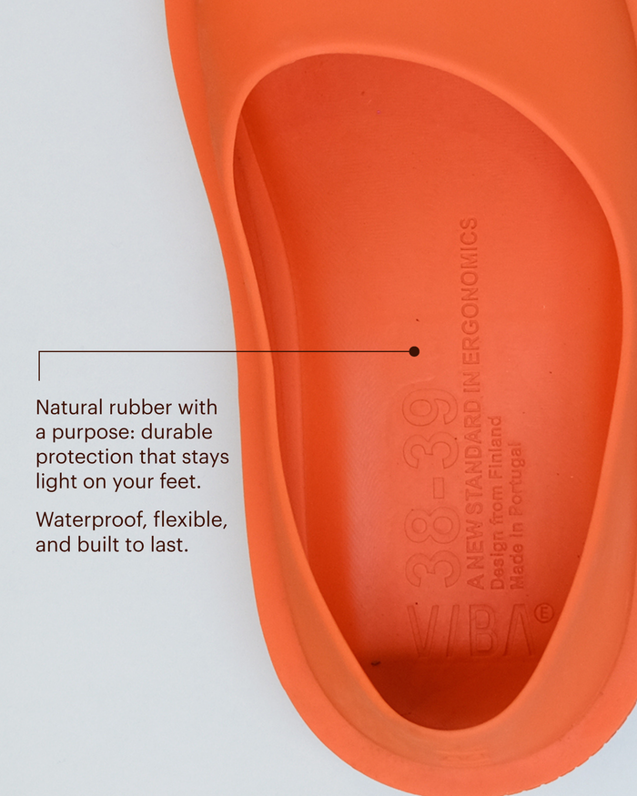 Bright orange natural rubber sole with oval footbed and embossed branding, shown from above.