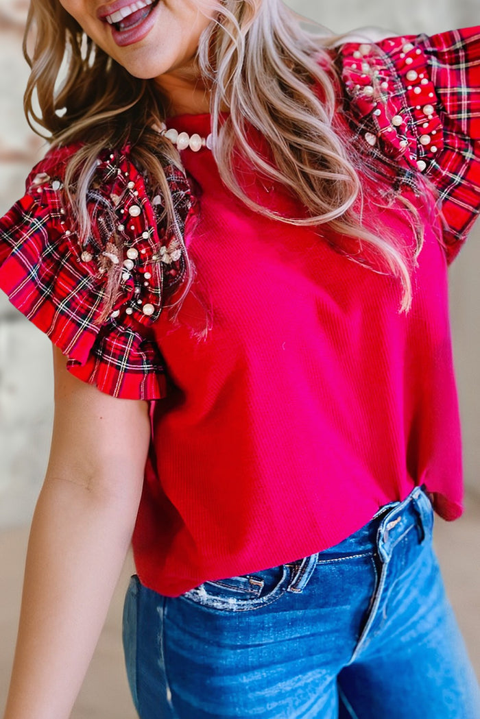red festive top with flared -festive-flutter style sleeves the sleeves are adorned with white faux pearls.