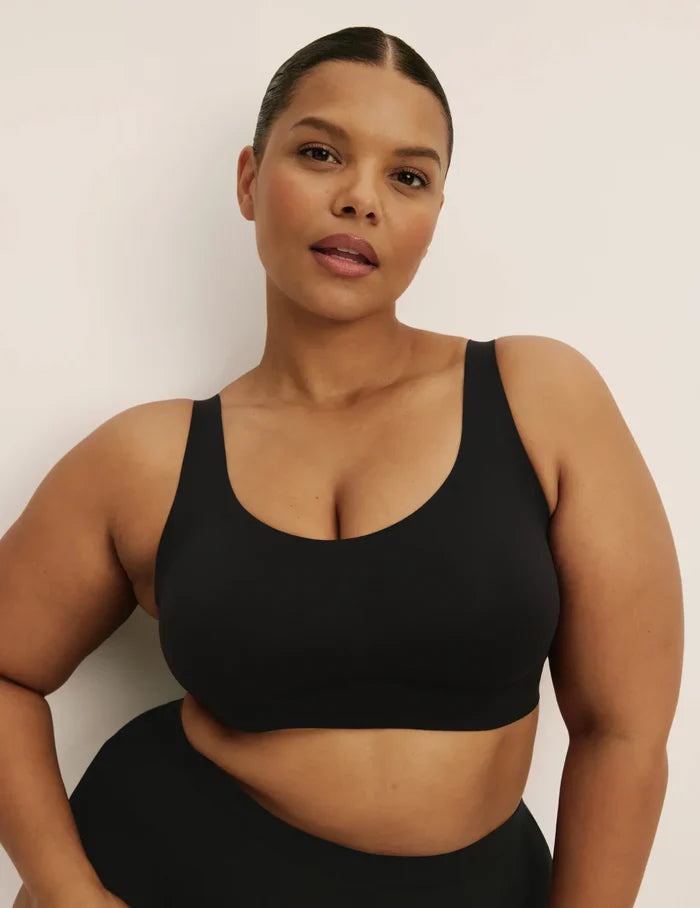 Leslie is a 38D and wearing KNIX XL+ | Front view of model wearing the Revolution Adjustable Pullover Bra, highlighting the neckline, strap design, and  silhouette | Black