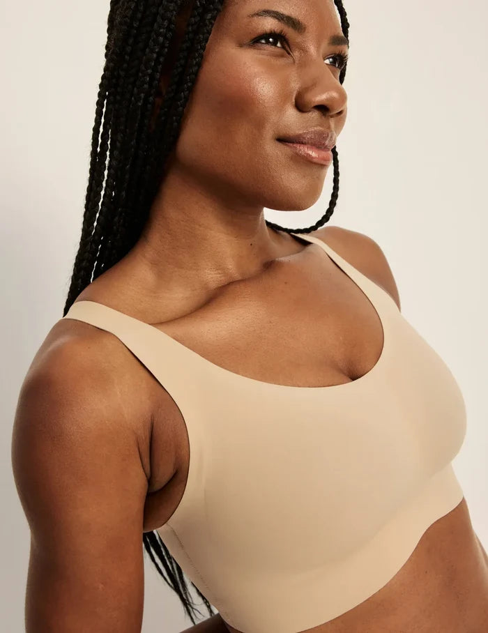 Gin is a 34DD and wearing KNIX M+ | Front view of model wearing the Revolution Adjustable Pullover Bra, highlighting the neckline, strap design, and  silhouette | Warm Sand
