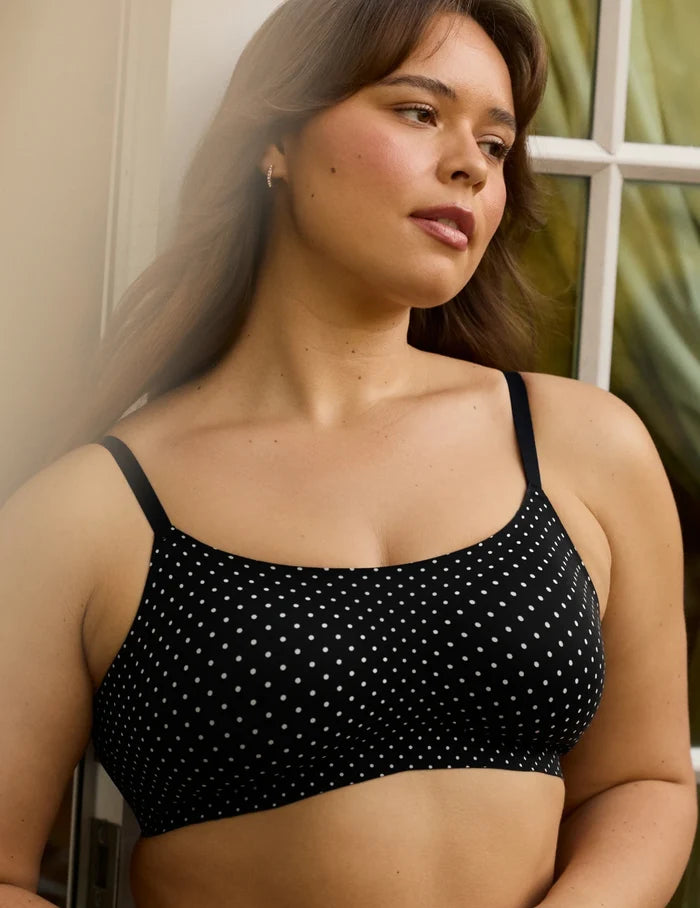 | Front view of model wearing the Revolution Scoop Bra, highlighting the neckline, strap design, and smooth silhouette | Black with White Polka Dot