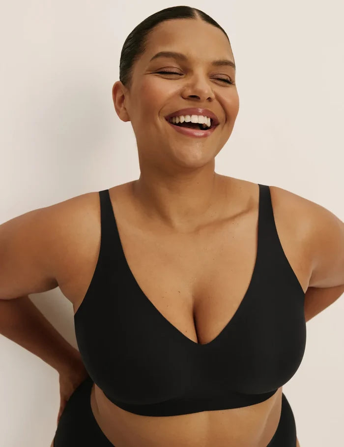 Leslie is a 38D and wearing KNIX XL+ | Front view of model wearing the Revolution V-Neck Bra, highlighting the neckline, strap design, and smooth silhouette | Black