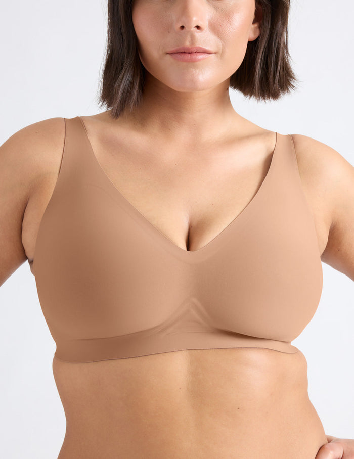 Maya is a 34F and wearing KNIX M++ | Front view of model wearing the Revolution V-Neck Bra, highlighting the neckline, strap design, and smooth silhouette | Cavassa