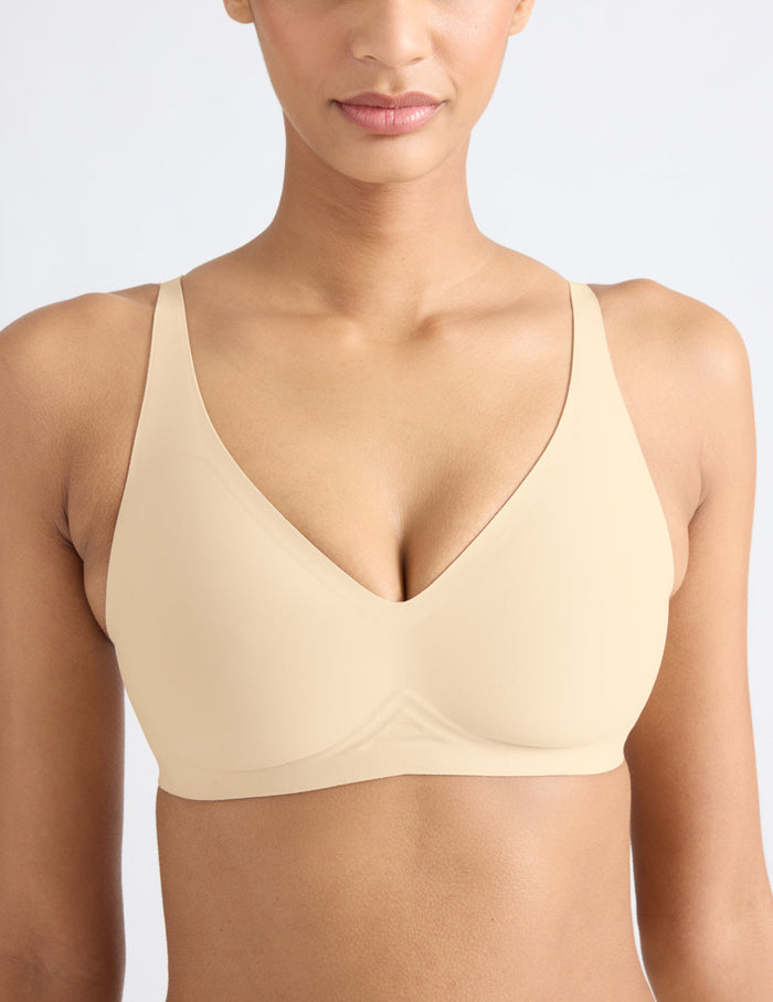 Tsanna is a 32C and wearing KNIX S | Front view of model wearing the Revolution V-Neck Bra, highlighting the neckline, strap design, and smooth silhouette | Dune