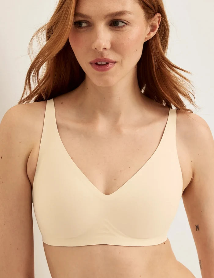 | Front view of model wearing the Revolution V-Neck Bra, highlighting the neckline, strap design, and smooth silhouette | Dune