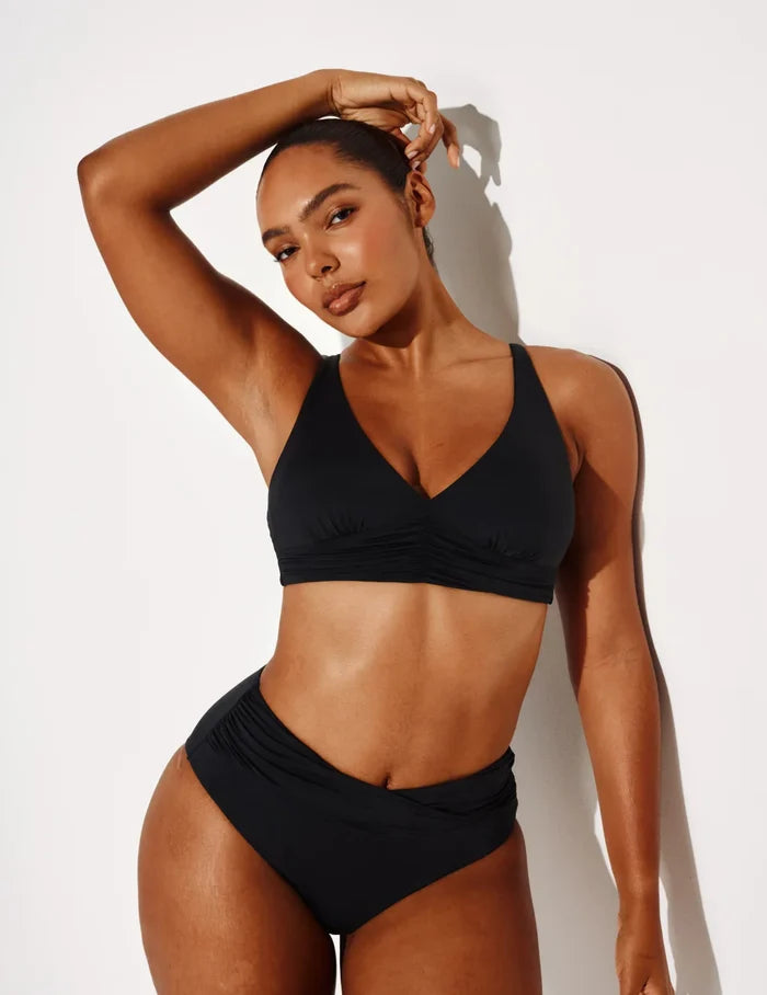Amber has 44” hips and wears a Knix size L | Front view of model wearing the Sculpt Ruched Bikini Swim Bottom highlighting the coverage and fit | Black