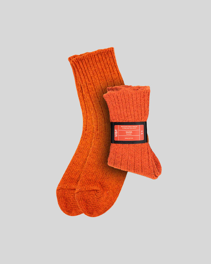 Pair of orange ribbed knit socks with a red product label band around one sock.