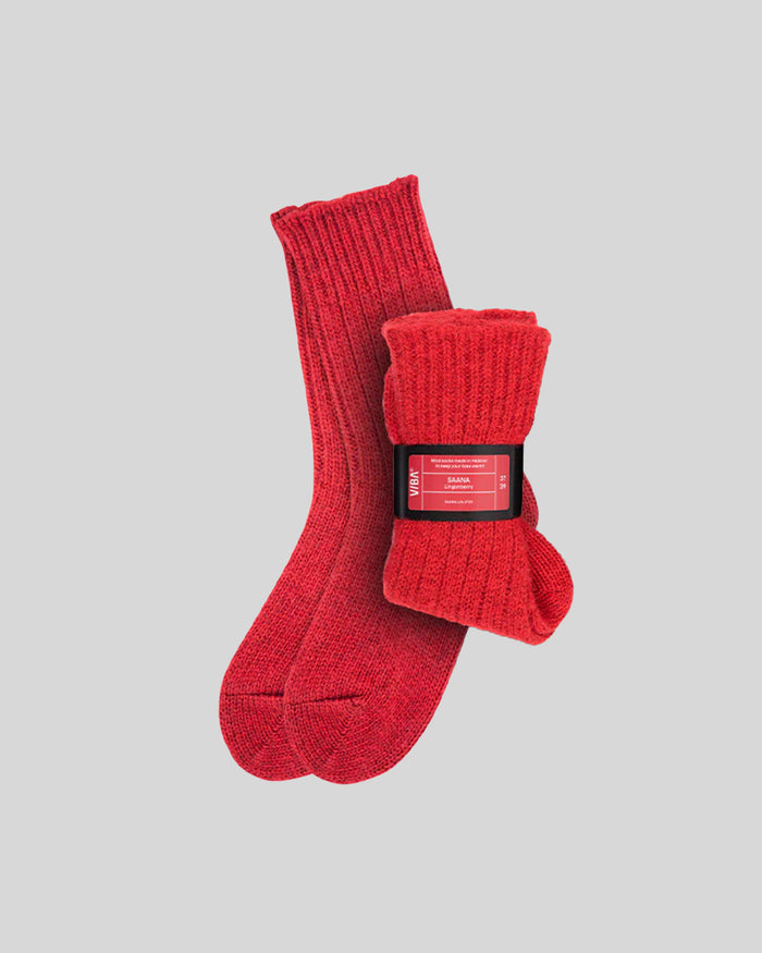 Pair of red ribbed knit socks with product label band around cuff.