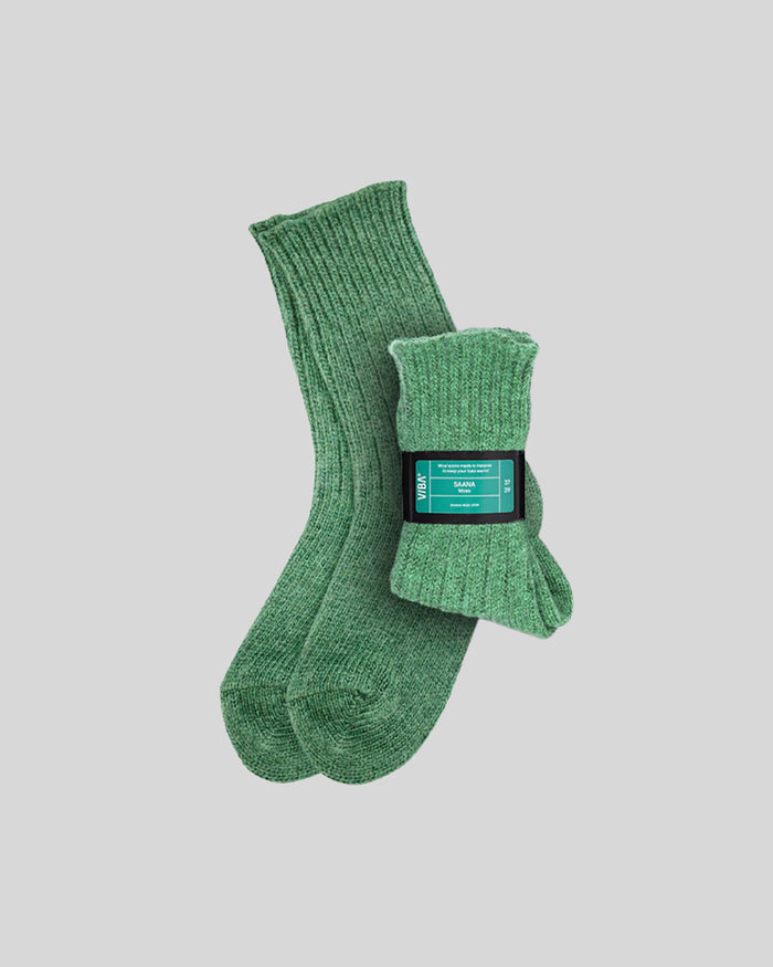 Pair of moss green ribbed knit socks with product label band against neutral background.
