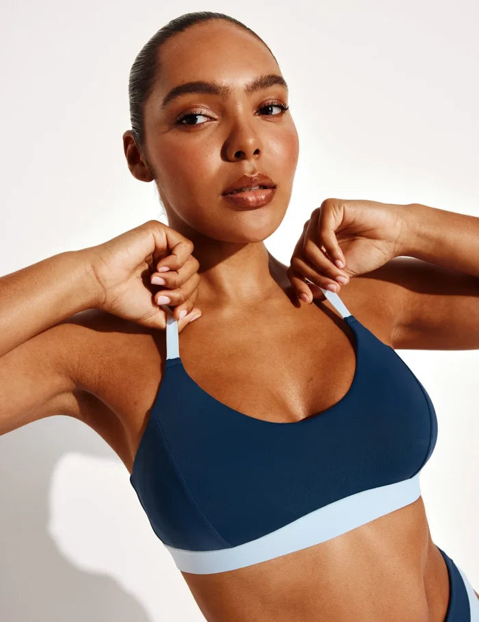 Amber is a 36C and wears a Knix size L | Front view of model wearing the Scoop Bikini Top, highlighting the neckline, strap design, and silhouette | Horizon/Blue Ice