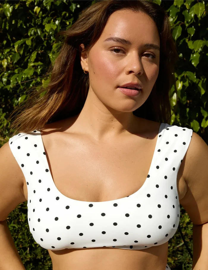 | Front view of model wearing the Sculpt Cap Sleeve Bikini Top, highlighting the neckline, strap design, and silhouette | White with Black Polka Dot