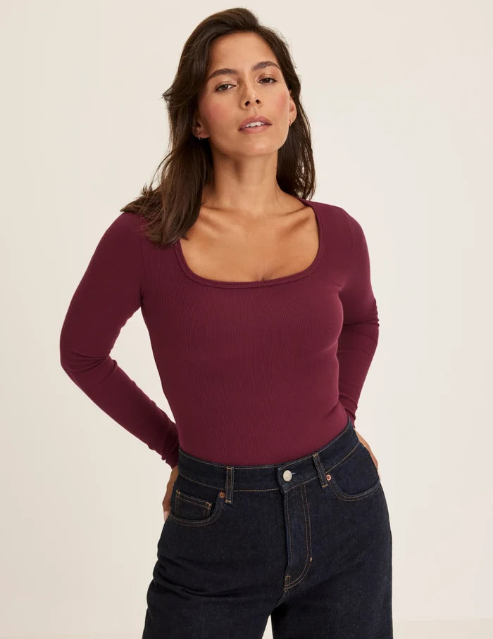 Maya is a 34DDD wearing KNIX M | Front view of model wearing the SculptRib™ Cotton Long Sleeve Top highlighting the neckline, fabric and hugging fit | Dark Cherry