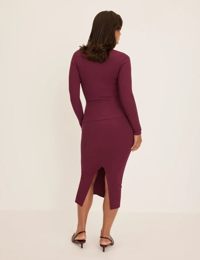 Maya has 40” hips and wearing KNIX M | Back view of model wearing the SculptRib™ Cotton Midi Pencil Skirt highlighting the hemline, fabric and hugging fit | Dark Cherry