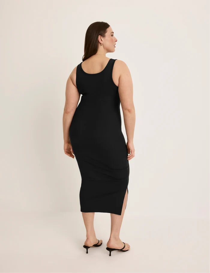 Beatrice is 5’7.5” tall and wearing KNIX XL | Back view of model wearing the SculptRib™ Cotton Tank Dress highlighting the neckline, hemline and hugging fit | Black