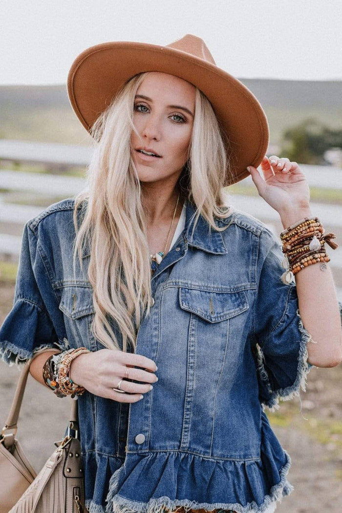 short sleeve denim jacket has 2 buttoned chest pockets sand a raw hem/ seam at the sleeves and sides.