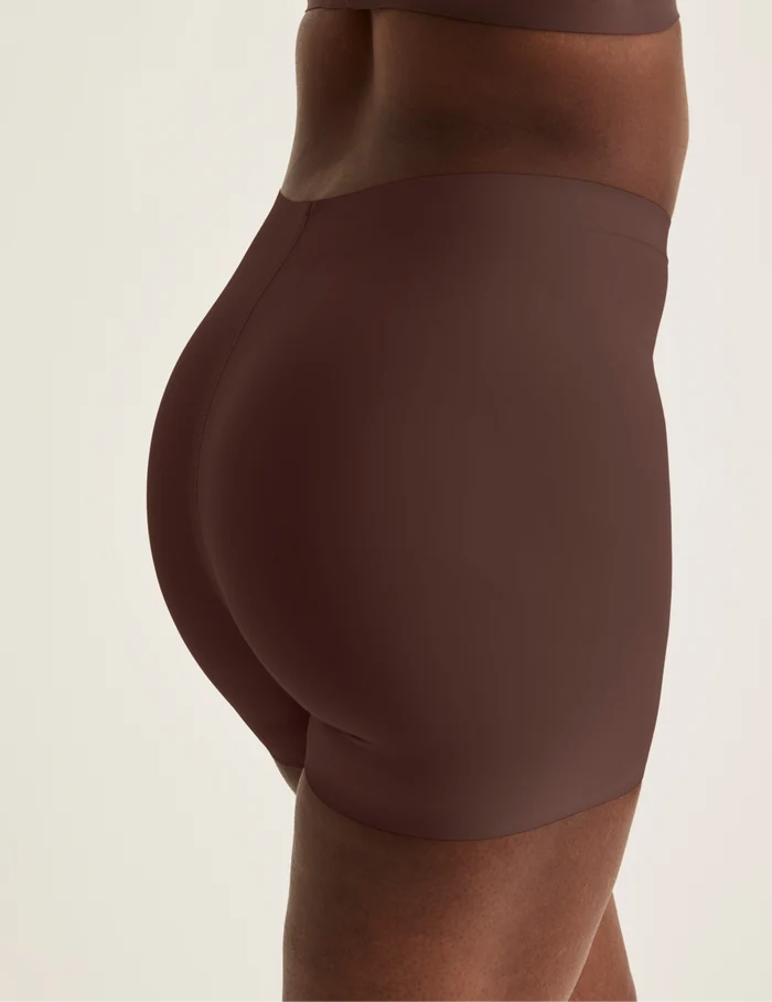 Orlane is wearing KNIX S | Back view of model wearing the Shortie Thigh Saver® 4”, highlighting the coverage and smooth fit | Sable