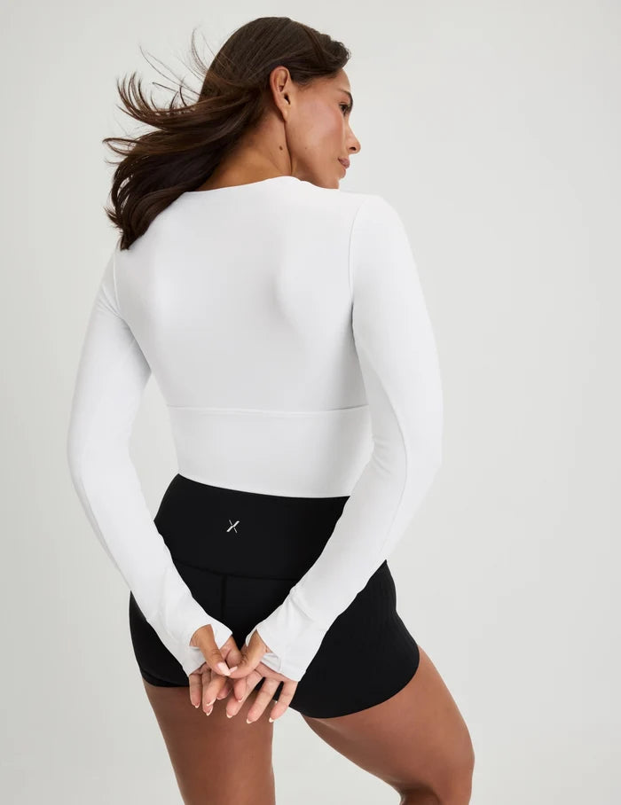 | Back view of model wearing the Studio Cutout Bra Top, highlighting the keyhole neckline, flattering design, and silhouette | White