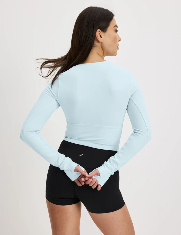 | Back view of model wearing the Studio Cutout Bra Top, highlighting the keyhole neckline, flattering design, and silhouette | Blue Light