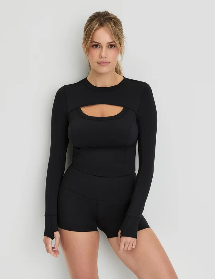 | Front view of model wearing the Studio Cutout Bra Top, highlighting the keyhole neckline, flattering design, and silhouette | Black