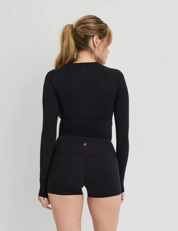 | Front view of model wearing the Studio Cutout Bra Top, highlighting the keyhole neckline, flattering design, and silhouette | Black