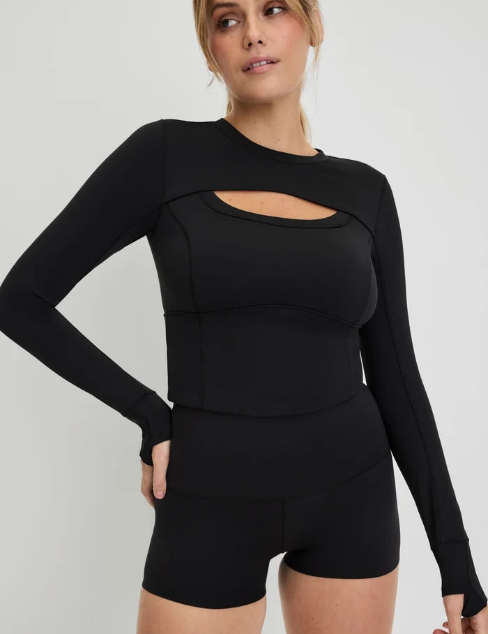 | Front view of model wearing the Studio Cutout Bra Top, highlighting the keyhole neckline, flattering design, and silhouette | Black