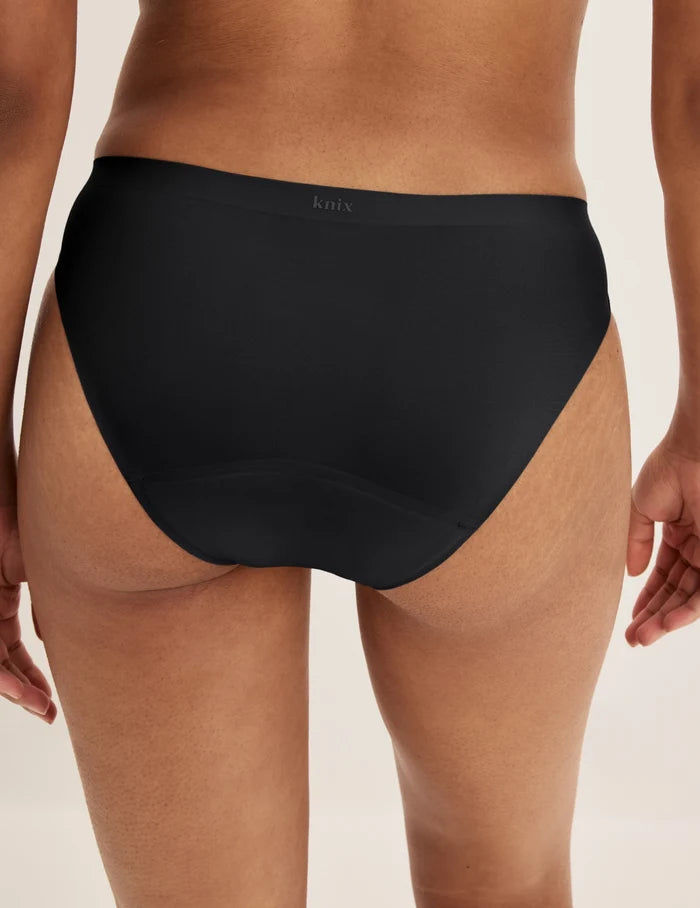 Ashley has 39” hips and wears KNIX S | Back view of model wearing the Super Leakproof® No-Show Bikini highlighting the coverage and smooth fit | Black