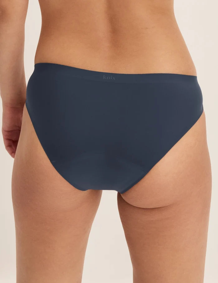 Megan has 36.5” hips and wears KNIX S | Back view of model wearing the Super Leakproof® No-Show Bikini highlighting the coverage and smooth fit | Twilight Navy