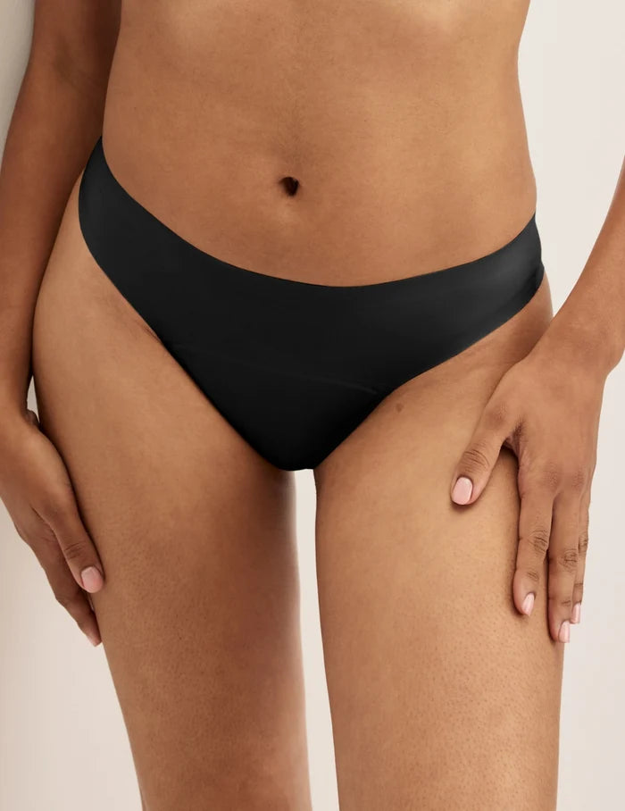 Ashley has 39” hips and wears KNIX S | Front view of model wearing the Super Leakproof® No-Show Thong highlighting the coverage and smooth fit | Black