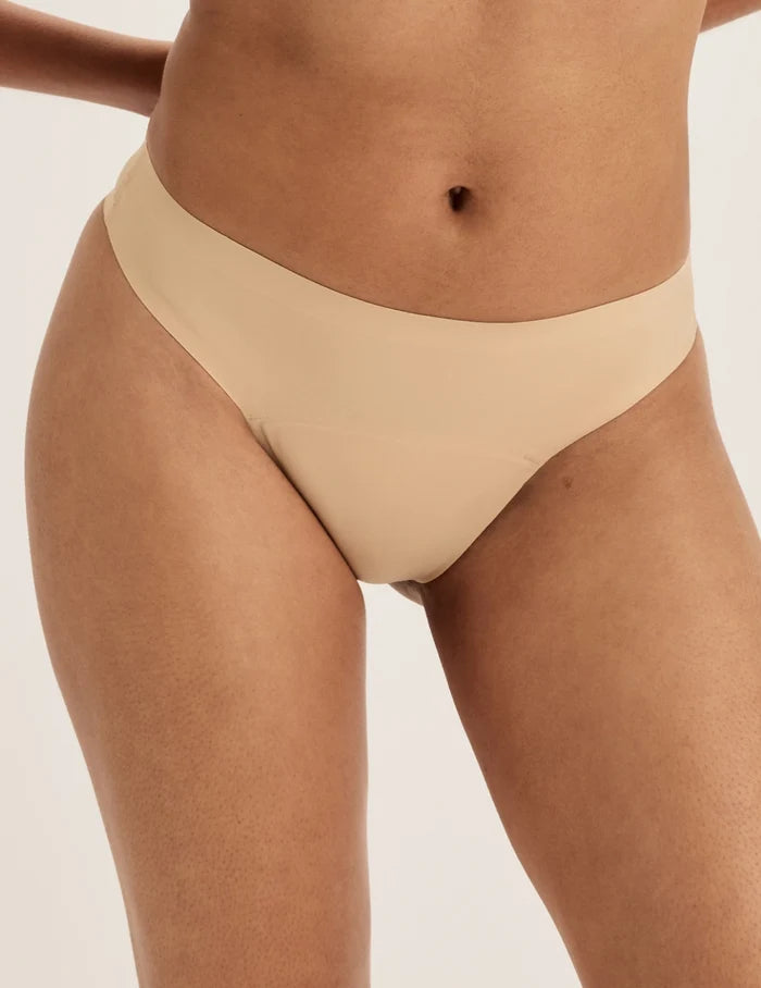 Ashley has 39” hips and wears KNIX S | Front view of model wearing the Super Leakproof® No-Show Thong highlighting the coverage and smooth fit | Warm Sand