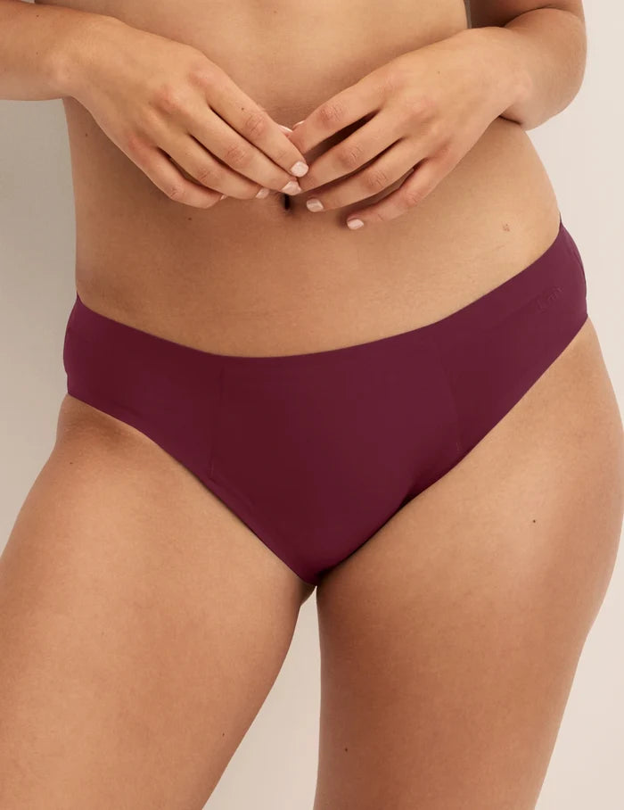 Megan has 36.5” hips and wears KNIX S | Front view of model wearing the SuperPlus Leakproof® No-Show Bikini highlighting the coverage and smooth fit | Dark Cherry