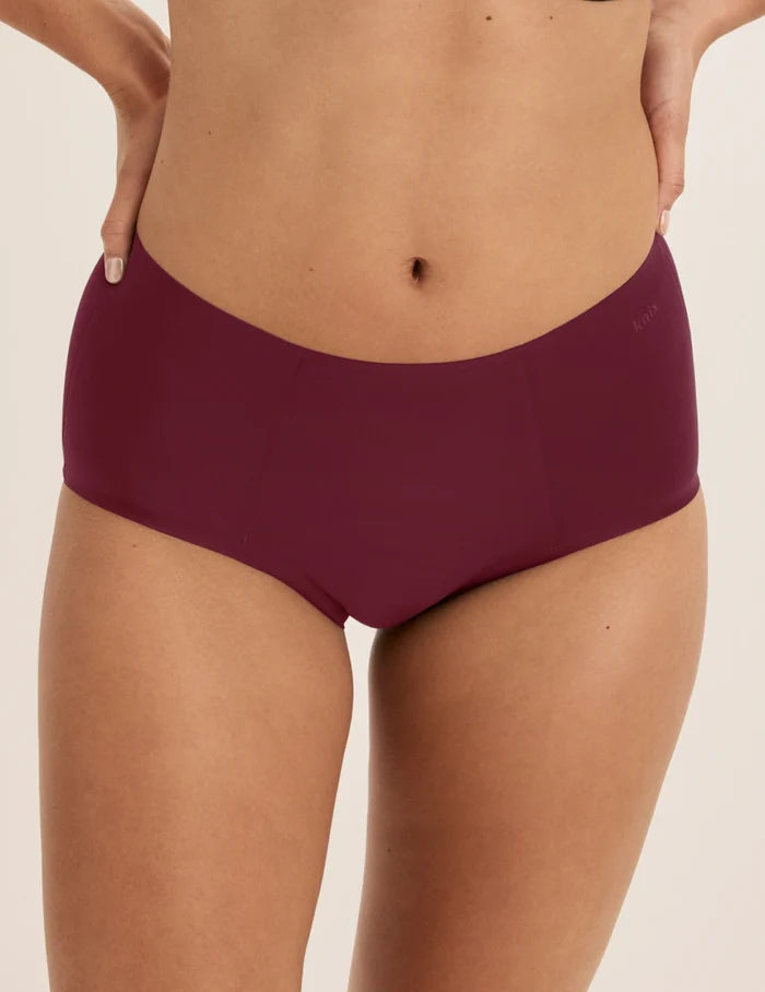 Megan has 36.5” hips and wears KNIX S | Front view of model wearing the SuperPlus Leakproof® No-Show Boybrief highlighting the coverage and smooth fit | Dark Cherry