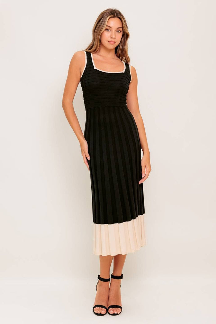 This sweater knit midi dress is black with cream white accents. The square neckline and pleated skirt make this dress timeless