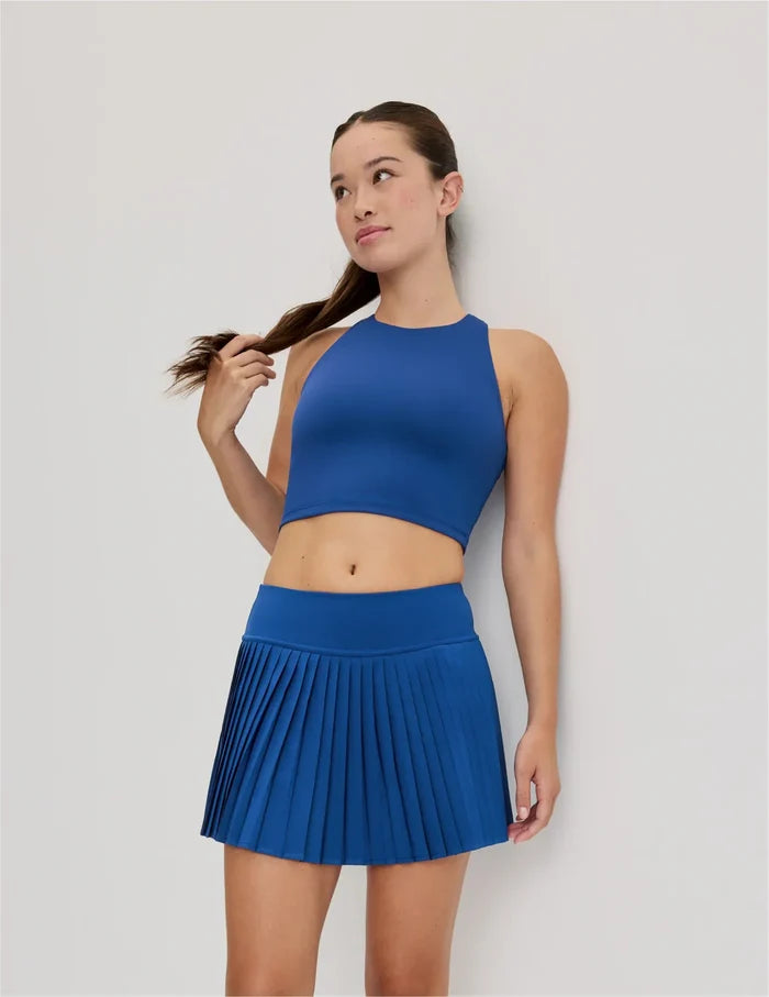 | Front view of model wearing the Teen First Serve Pleated Skort highlighting the coverage and fit | Shady Blue