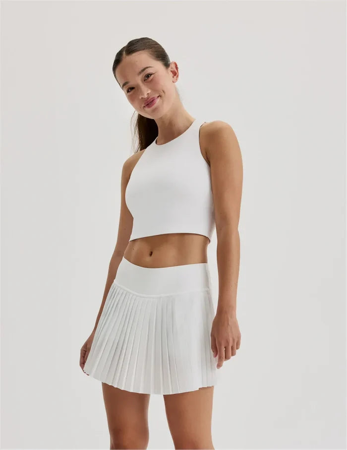 | Front view of model wearing the Teen First Serve Pleated Skort highlighting the coverage and fit | White