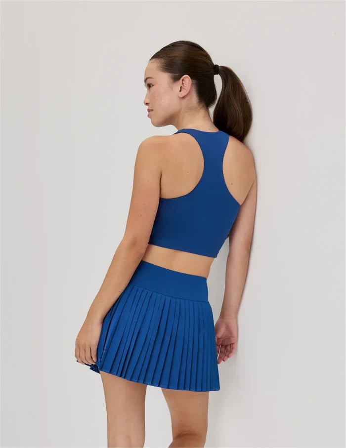 | Back view of model wearing the Teen First Serve Pleated Skort highlighting the coverage and fit | Shady Blue