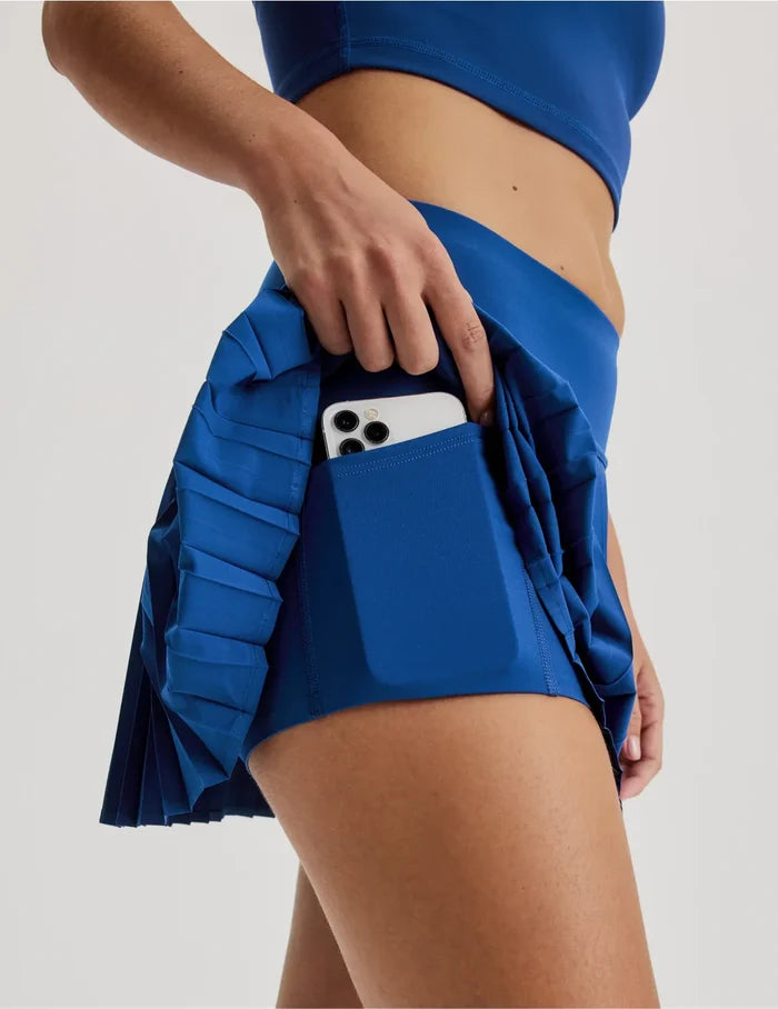 | Front view of model wearing the Teen First Serve Pleated Skort highlighting the coverage and fit | Shady Blue