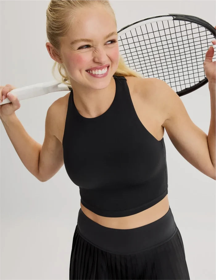 | Front view of model wearing the Teen First Serve Racerback Tank highlighting the coverage and fit | Black