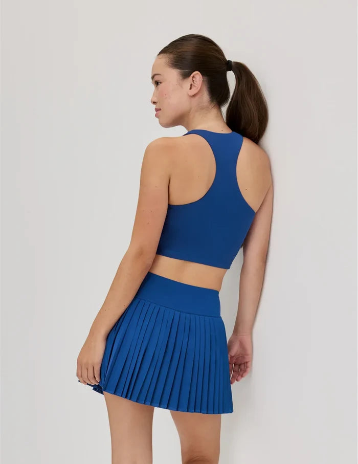 | Back view of model wearing the Teen First Serve Racerback Tank highlighting the coverage and fit | Shady Blue