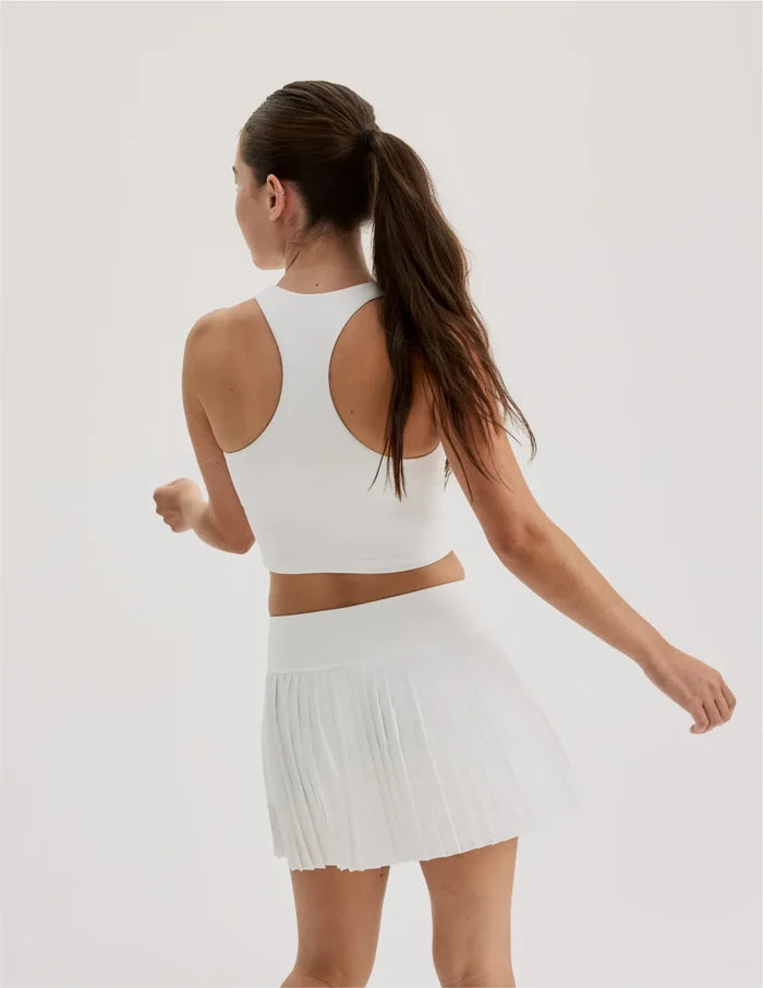 | Back view of model wearing the Teen First Serve Racerback Tank highlighting the coverage and fit | White