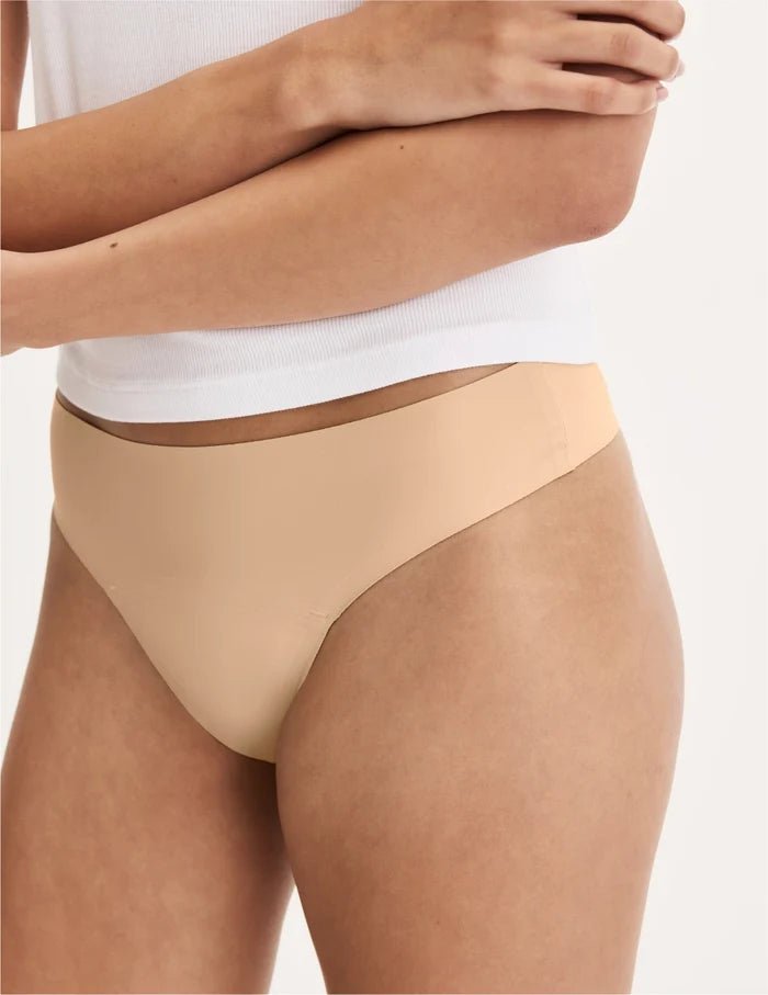 | Front view of model wearing the Teen Leakproof UltraThin No-Show Thong highlighting the coverage and smooth fit | Warm Sand