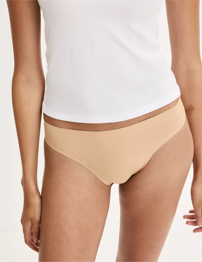 | Front view of model wearing the Teen Leakproof UltraThin No-Show Thong highlighting the coverage and smooth fit | Warm Sand