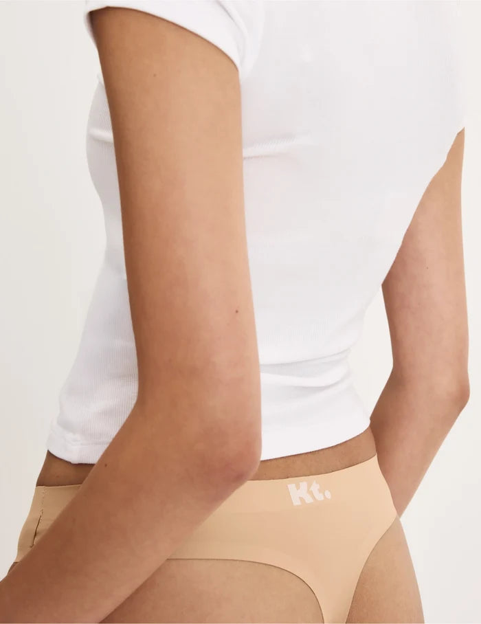 | Back view of model wearing the Teen Leakproof UltraThin No-Show Thong highlighting the coverage and smooth fit | Warm Sand