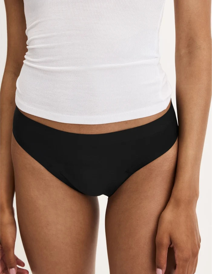 | Front view of model wearing the Teen Leakproof UltraThin No-Show Thong highlighting the coverage and smooth fit | Black